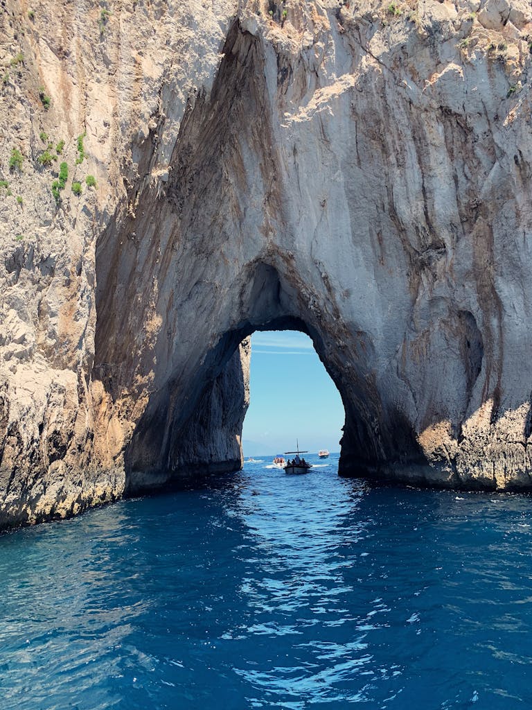 Stunning rock archway over blue waters at Capri, Italy, capturing natural beauty.